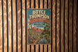 A vintage-style metal sign for Boyce Thompson Arboretum in Arizona, featuring a desert landscape with cacti and a mountain backdrop.
