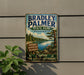 A vintage metal sign for Bradley Palmer State Park in Massachusetts, featuring a scenic landscape with a lake and pine trees.