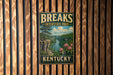 A vintage-style metal sign for Kentucky Interstate Park, featuring a scenic landscape with a river, mountains, and pink flowers.