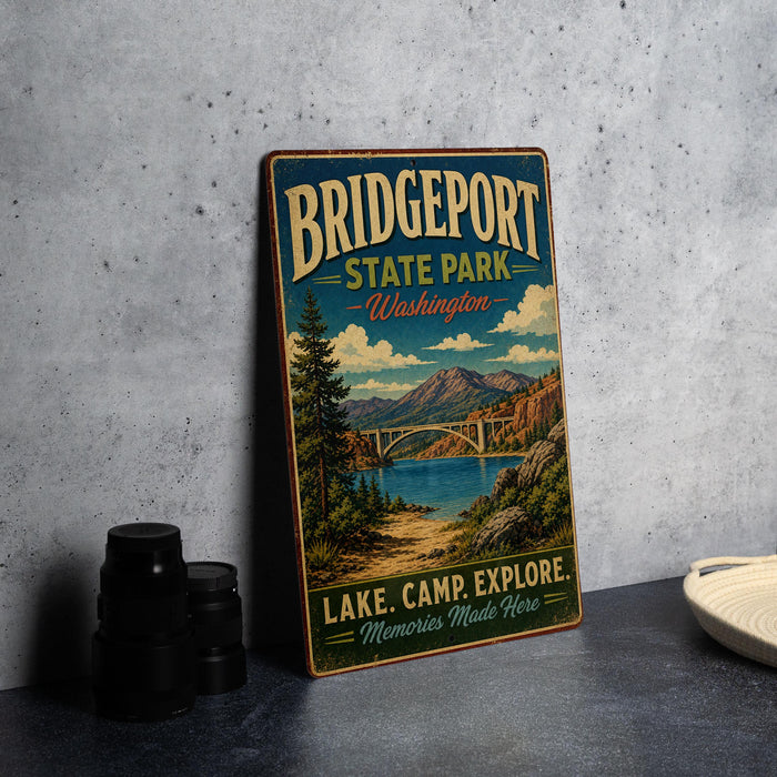 A vintage-style metal sign for Bridgeport State Park in Washington, featuring a scenic landscape with a lake, bridge, and mountains.