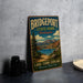 A vintage-style metal sign for Bridgeport State Park in Washington, featuring a scenic landscape with a lake, bridge, and mountains.