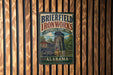 A vintage metal sign for Brierfield Ironworks Historical State Park in Alabama, featuring an illustration of a steam tower and a wooden fence.