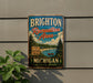 A vintage metal sign for Brighton Recreation Area in Michigan, featuring a scenic landscape with a lake, pine trees, and a sign inviting visitors to "Play, Explore, Relax".