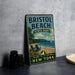 A vintage-style sign for Bristol Beach State Park, featuring a beach scene with a sailboat and a wooden bench, along with the text "Bristol Beach State Park - New York - Great Outdoors - New York".