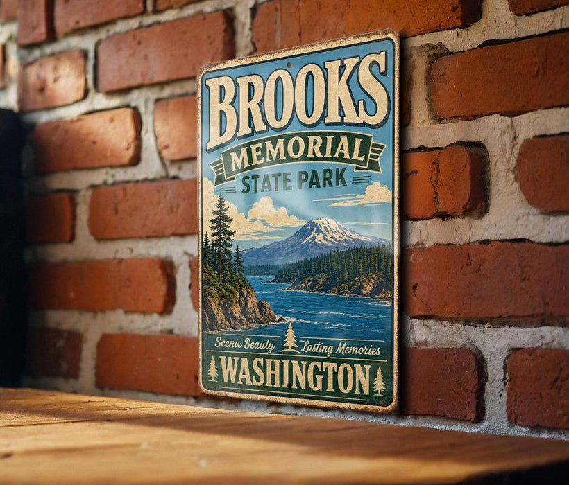 A vintage metal sign for Brooks Memorial State Park in Washington, featuring a scenic mountain landscape and a river.