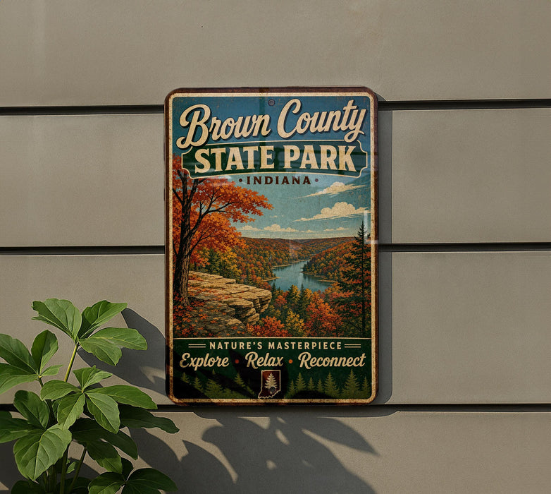 A vintage-style sign for Brown County State Park in Indiana, featuring a scenic landscape with a river and autumn foliage.