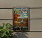 A vintage-style sign for Brown County State Park in Indiana, featuring a scenic landscape with a river and autumn foliage.