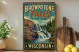 A vintage-style sign for Brownstone Falls State Park in Wisconsin, featuring a scenic image of a waterfall surrounded by trees and mountains.