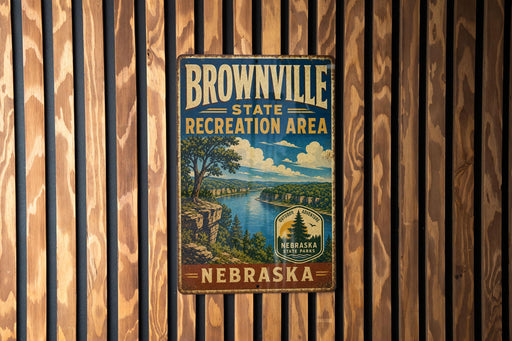 A vintage metal sign for the Brownville State Recreation Area in Nebraska, featuring a scenic landscape with a river and mountains.