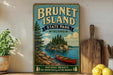 A vintage-style poster of Brunet Island, Wisconsin, featuring a canoe on a lake surrounded by pine trees, is displayed on a wall next to a wooden cutting board and some lemons.