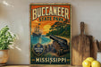 A vintage-style sign for Buccanee State Park, featuring a ship, palm trees, and a cannon, is displayed on a shelf next to a wooden cutting board and some lemons.