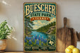 A vintage-style metal sign for Buescher State Park in Texas, featuring a scenic landscape with pine woods, lakes, and trails.