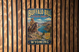 A vintage metal sign for Buffalo Bill State Park in Wyoming, featuring a cowboy on horseback and a scenic landscape.