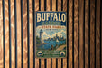 A vintage-style metal sign for Buffalo Harbor State Park in New York, featuring a lighthouse and a cityscape, mounted on a wooden wall.