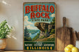 A vintage-style sign for Buffalo Rock State Park in Illinois, featuring a scenic landscape with a cliff and lake.