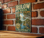 A vintage-style sign for Bulow Creek State Park in Florida, featuring palm trees and a bird, is displayed on a brick wall.