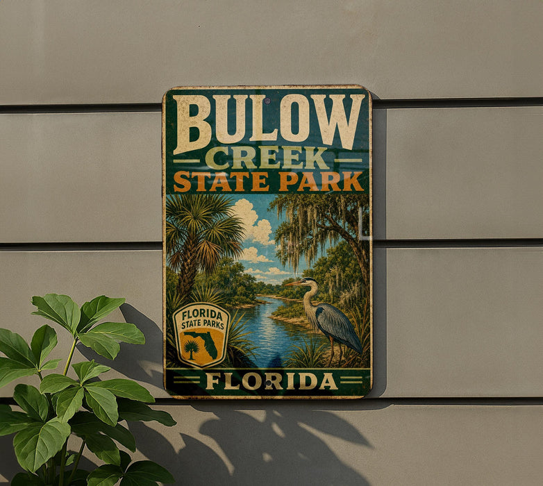 A vintage-style sign for Bulow Creek State Park in Florida, featuring a palm tree and a bird, mounted on a wall.