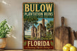 A vintage-style sign for Bulow Plantation Ruins Historic State Park in Florida, featuring a picture of the ruins and the text "Bulow Plantation Ruins Florida Preserving Florida's Heritage".