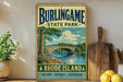 A vintage metal sign for Burlingame State Park, featuring a scenic illustration of a bridge over a river surrounded by nature, with the text "Burlingame State Park" and "RhoDE ISLAND" prominently displayed.