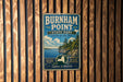 A vintage metal sign for Burnham Point State Park in New York, featuring a scenic landscape with a lake, mountains, and pine trees.