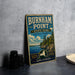 A vintage-style metal sign for Burnham Point State Park, featuring a scenic landscape with a body of water and mountains in the background.