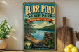 A vintage-style sign for Burr Pond State Park in Connecticut, featuring a scenic landscape with a lake and forest.