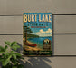 A vintage-style sign for Burt Lake State Park in Michigan, featuring a canoe on a lake and a scenic landscape.