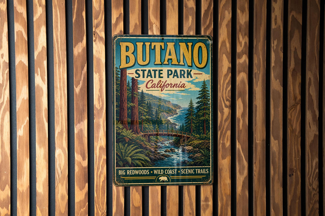 A vintage metal sign for Butano State Park, California, featuring a scenic landscape with a river, mountains, and trees.