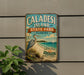 A vintage-style metal sign for Caladesi Island, Florida, featuring a blue background with a large blue heron and a white sailboat in the distance.