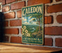 A vintage metal sign for Caledon State Park in Virginia, featuring a scenic landscape with a river, trees, and flowers.