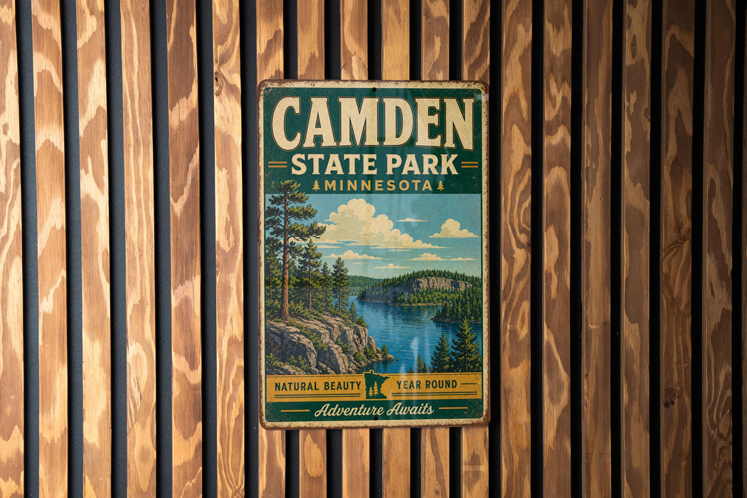 A vintage metal sign for Camden State Park in Minnesota, featuring a scenic landscape with a lake and mountains.