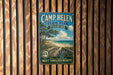 A vintage metal sign for Camp Helen State Park in Florida, featuring a beach scene with palm trees and a wooden walkway leading to the beach.