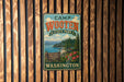 A vintage metal sign for Camp Wooten State Park in Washington, featuring a scenic landscape with a mountain, lake, and forest.