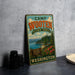 A vintage-style metal sign for Camp Wooten State Park in Washington, featuring a scenic landscape with a mountain, lake, and cabin.
