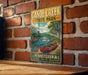 A vintage metal sign for Canoe Creek State Park in Pennsylvania, featuring a scenic illustration of a canoe on a river surrounded by trees and mountains.