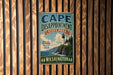 A vintage-style metal sign for Cape Disappointment State Park in Washington, featuring a lighthouse and a coastal landscape.