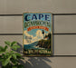 A vintage-style metal sign for Cape Disappointment State Park in Washington, featuring a lighthouse and a scenic coastal landscape.