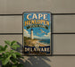 A vintage-style metal sign for Cape Henlopen State Park in Delaware, featuring a lighthouse and beach scene.