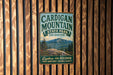 A vintage-style metal sign for Cardigan Mountain State Park in New Hampshire, featuring a scenic mountain landscape.