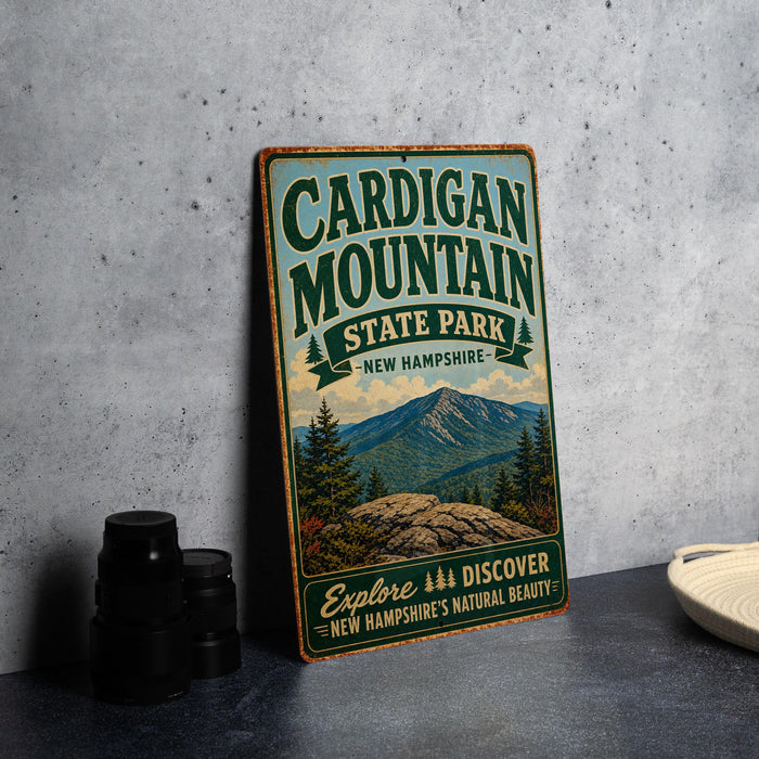 A vintage-style metal sign for Cardigan Mountain State Park in New Hampshire, featuring a scenic mountain landscape and the text "Explore New Hampshire's Natural Beauty".