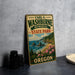 A vintage-style metal sign for Carl G. Washburne Memorial State Park in Oregon, featuring a scenic landscape with mountains, water, and flowers.