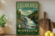 A vintage-style sign for Cascade River State Park in Minnesota, featuring a scenic image of a waterfall surrounded by pine trees.