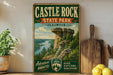 A vintage-style sign for Castle Rock State Park in Illinois, featuring a scenic landscape with a rock formation and a river.