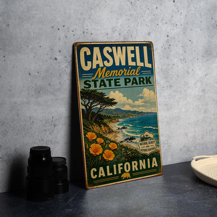 A vintage-style metal sign for Caswell Memorial State Park in California, featuring a scenic landscape with a beach, mountains, and trees.