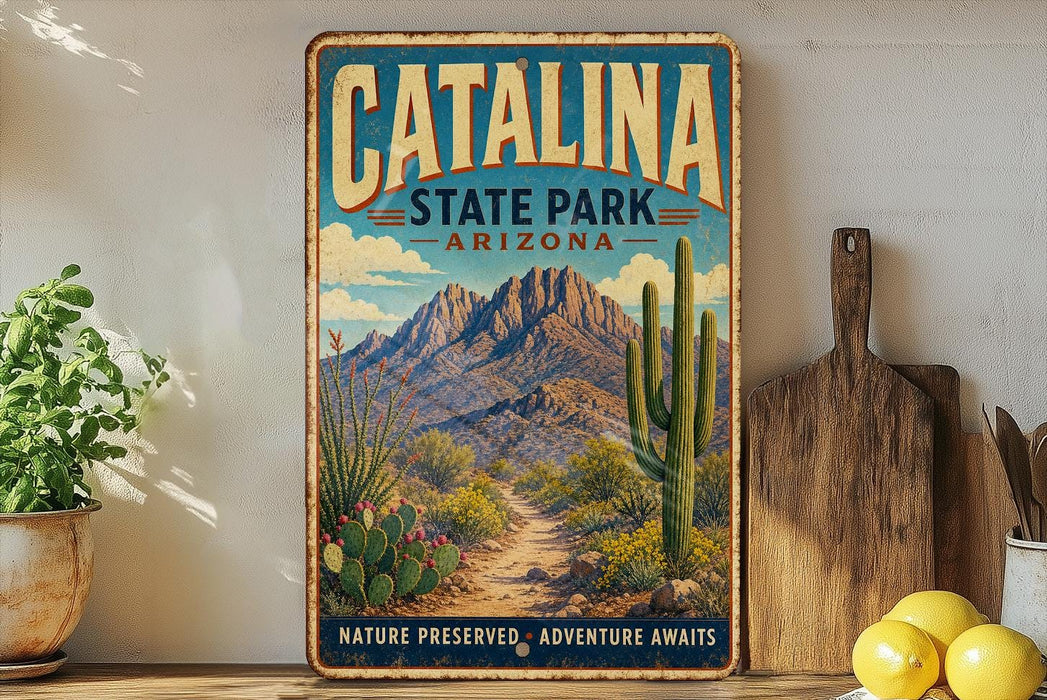 A vintage-style metal sign for Catalina State Park in Arizona, featuring a desert landscape with mountains, cacti, and a path leading to the park.