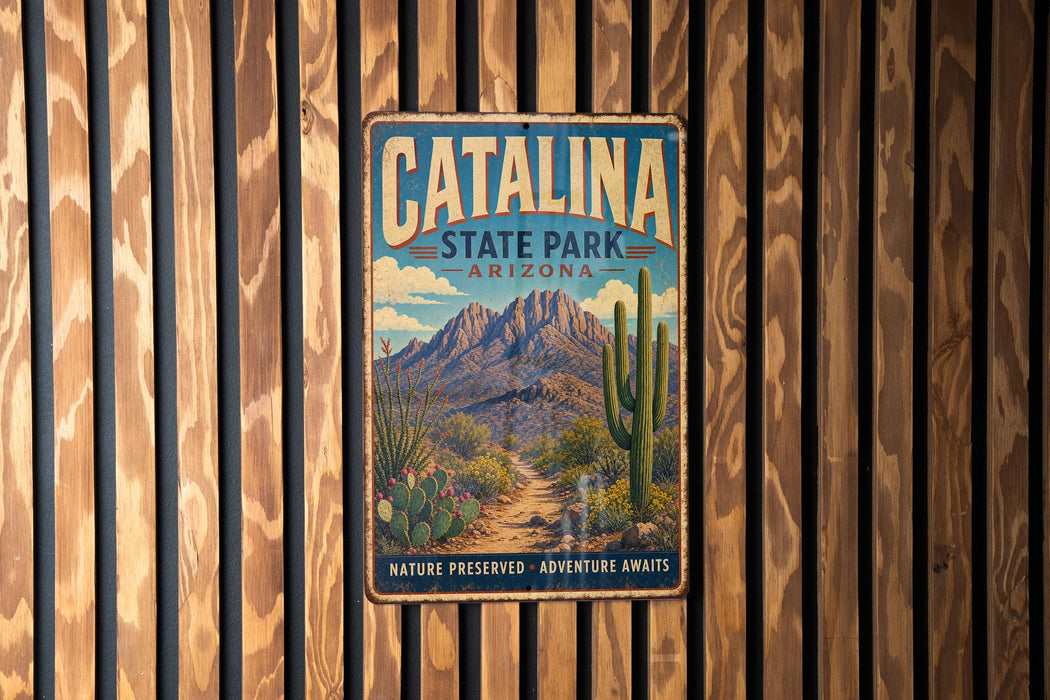 A vintage metal sign for Catalina State Park in Arizona, featuring a desert landscape with mountains, cacti, and a trail.