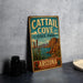 A vintage-style metal sign for Catail Cove State Park in Arizona, featuring a desert landscape with mountains and a cactus in the foreground.