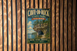 A vintage-style metal sign for Cave-in-Rock State Park in Illinois, featuring a scenic image of a rocky cliff with a lake below.