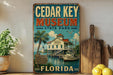 A vintage-style sign for the Cedar Key Museum in Florida, featuring a tropical beach scene with palm trees, a lighthouse, and a boat.