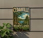 A vintage metal sign for Cedarville State Forest in Maryland, featuring a scenic image of a forest and a lake.
